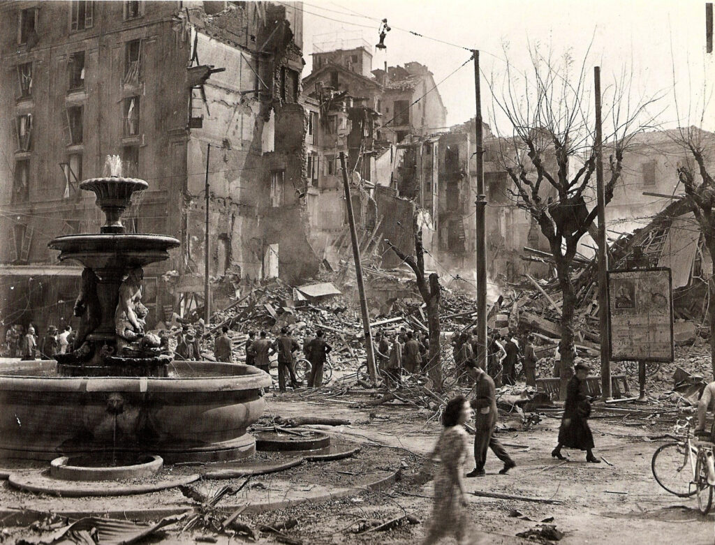 Foto storica del quartiere San Lorenzo a Roma dopo il bombardamento del 19 luglio 1943, con macerie e la fontana danneggiata.